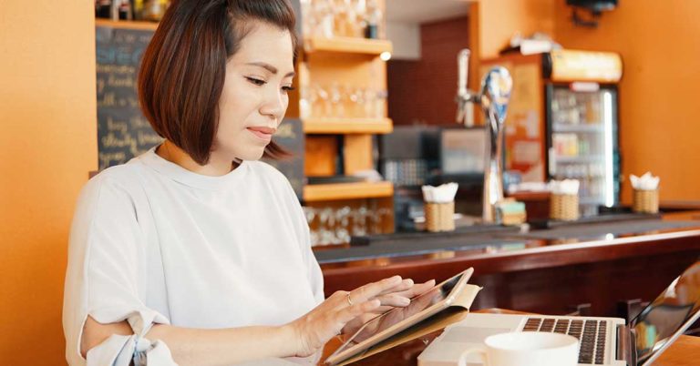 Female coffee shop owner using a tablet