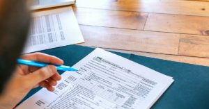 Man filling out printed tax documents